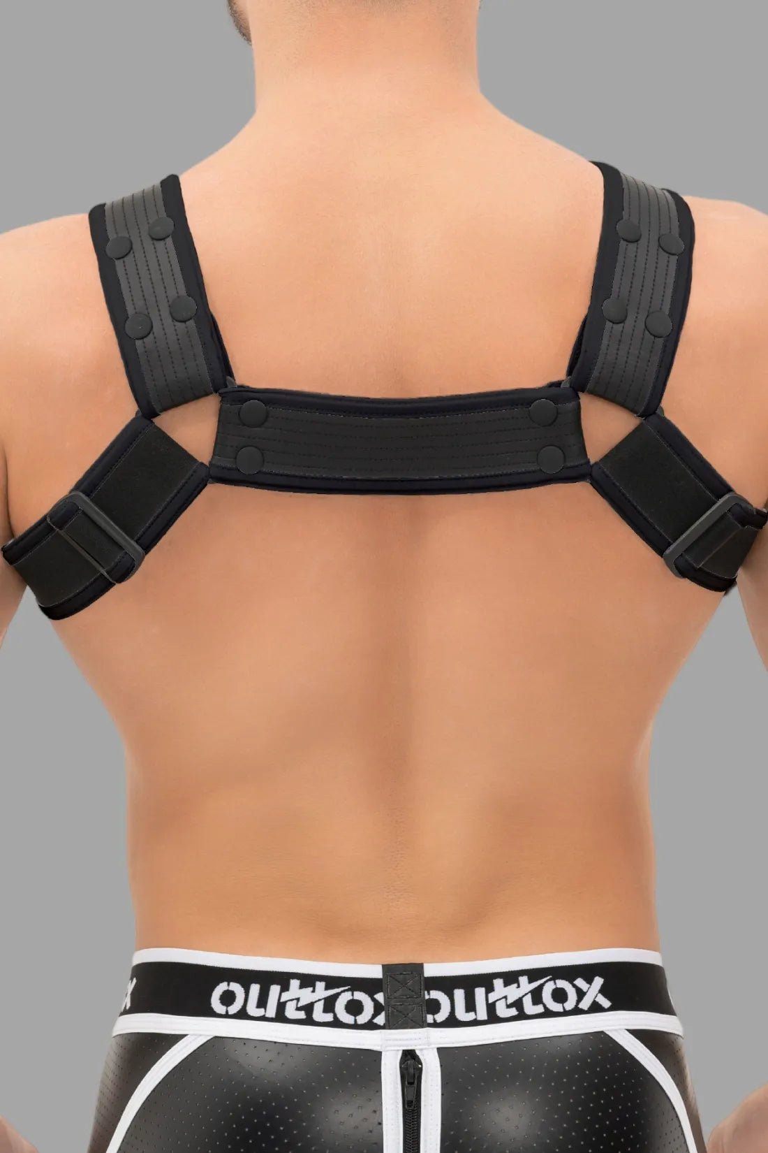 Outtox Black Harness with Snaps by Maskulo. Polyester/polyurethane/elastane blend, adjustable fit, with integrated cockring for enhancement.